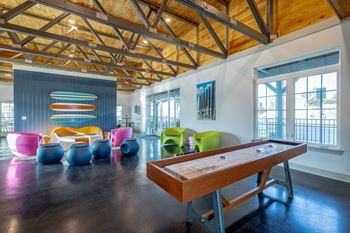 a game room with a pool table and colorful chairs